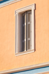Old window shutters on orange home