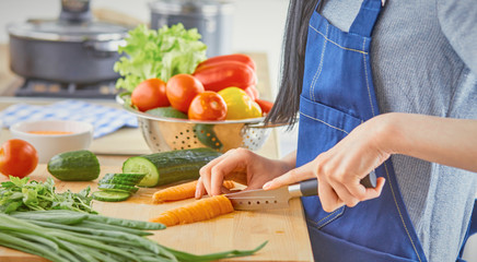 A young woman prepares food in the kitchen. Healthy food - vege