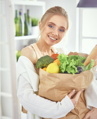 Young woman holding grocery shopping bag with vegetables Standi