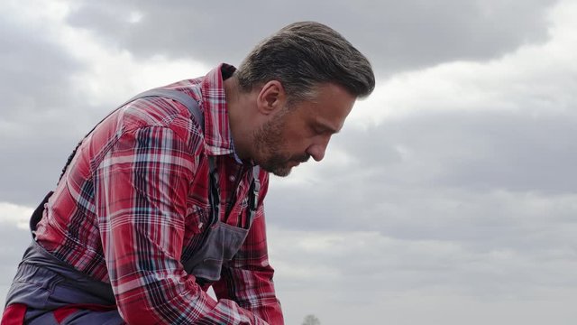 Farmer cheking soil on a field