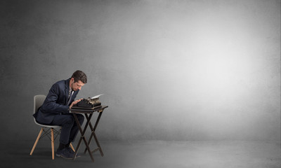 Man working hard on a typewriter in an empty space