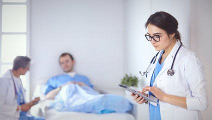 Doctor checking heart beat of patient in bed with stethoscope
