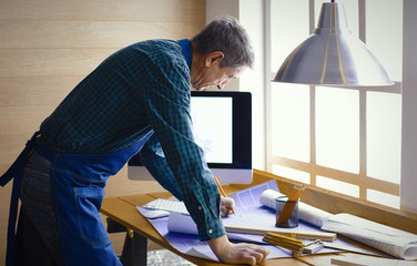 Engineer carpenter working on laptop and sketching project