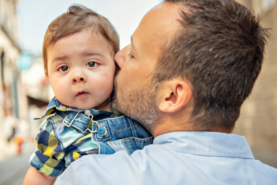 little baby son with father in city hagging and smiling, casual look outside