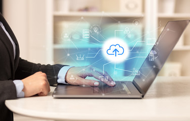 Business woman in homey environment using laptop with online storage and cloud technology concept