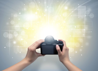 Naked hand taking picture with digital camera and glowing flash concept