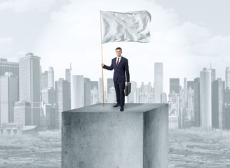 Handsome businessman on the top of the city with white flag
