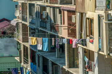 Colorful clothes drying in Georgia hangs down from the balconies. Traditional Georgian method of drying clothes on a sunny day