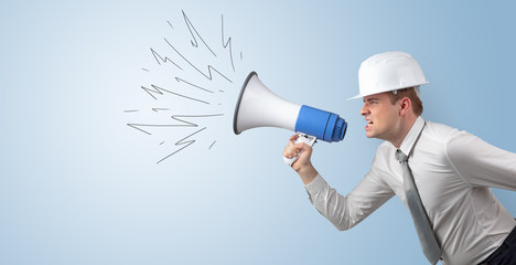 Fototapeta premium Young architect constructor yelling with megaphone and copyspace