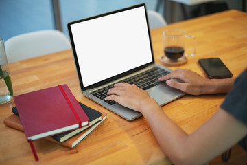Female person sitting front open laptop computer with blank empty screen for your information or content, modern businessman work in internet via notebook, student at coffee shop learning.