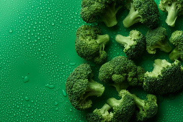 Fresh raw broccoli on green background with copy space, top view. The concept of healthy food,...