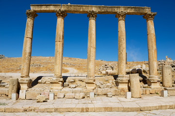 Fototapeta premium Corinthian Columns over the blue sky at the ruins of the Colonnade street in the ancient Roman city of Gerasa (modern Jerash) in Jordan.