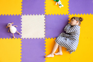 Little girl with autistic disorder lying on floor, top view