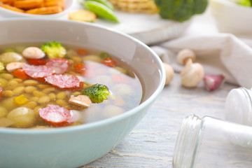 Tasty soup with legumes in bowl on table
