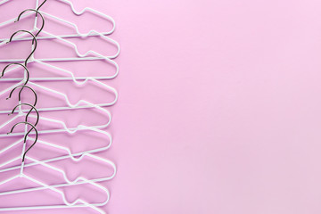 Many clothes hangers on color background