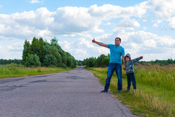 father and son hitchhiking along a road