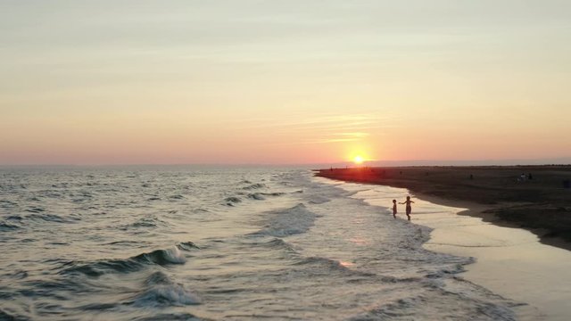 Sunset footage over the mediterranean sea withd kids playing.  Flying at a low altitude at Espiguette beach, port camargue