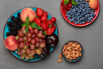 Seasonal fruits and nuts on concrete table, fresh ingredients for lunch. Healthy food concept. Top...