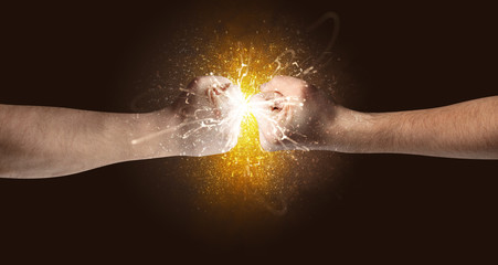 Fototapeta na wymiar Two hands fighting with orange dust, spark, glow and smoke concept