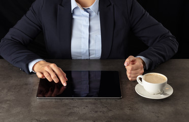 Fototapeta na wymiar Business woman working on tablet with dark background and copyspace