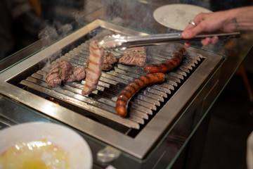 different types of meat, beef steaks and pork sausages, cooked on a grill