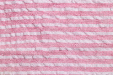 Textile background texture. Top view of details of a empty pink white striped summer dress. Beautiful backdrop for product display montage.