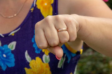 the hand is clenched. Woman threatens with a fist. Gesture with hands.