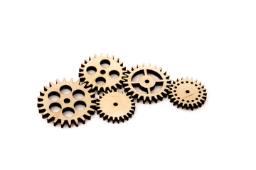 connected wooden gears of different size isolated on white background.