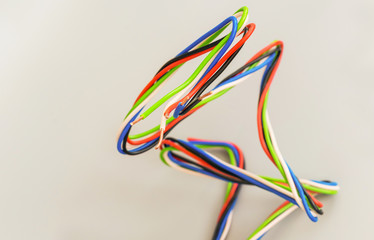 Electric wires of different colors in curved form on a gray background