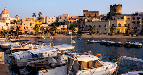 Sunset view on boats from the Marina of Forio, Ischia island, Italy. Soccorso Church, castle of...