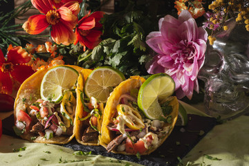 Fototapeta na wymiar Tacos crowned with lime surrounded by flowers