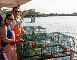 Two tourists working on lobster boat in Portand Maine