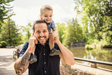 Fototapeta na wymiar Happy father having fun with his son on the park