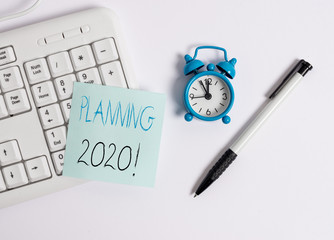 Text sign showing Planning 2020. Business photo text process of making plans for something next year White pc keyboard with empty note paper above white background