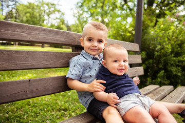 Two children brother are sitting on a bench