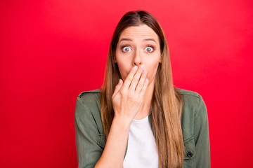 Photo of nice cute attractive woman covering her mouth seeming to have spoken something wrong while isolated with red background