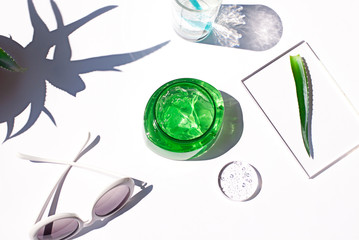 Aloe vera fresh gel in a plastic bottle flat lay on the white background. After sun cooling skin cosmetics top view