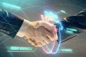 Multi exposure of heart hologram on abstract background with two men handshake. Concept of medical education