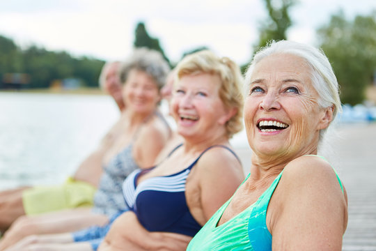 Laughing senior woman in swimsuit by the lake