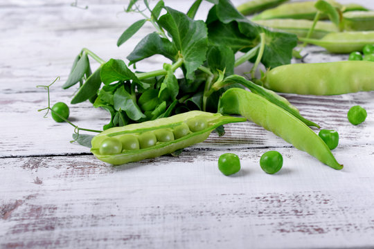 Young green peas on white wooden table