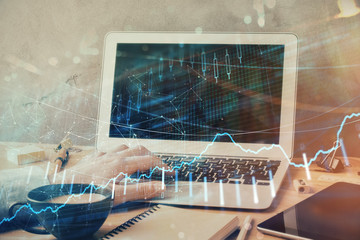 Forex graph with businessman working on laptop on background. Concept of hardworking. Multi exposure.
