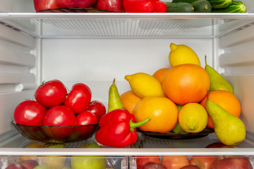 Refrigerator filled with useful products. Vegetables and fruits. Cucumbers, tomatoes and peppers, apples, pears, lemons, oranges and grapefruits. Diet, vegetarianism, weight loss concept