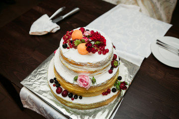wedding cake with fruit and a plate with a fork and a knife