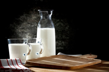 Fresh milk on desk and black space 
