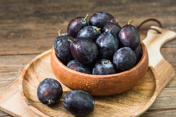 Juicy plums wooden utensils on a wooden table. Rustic style