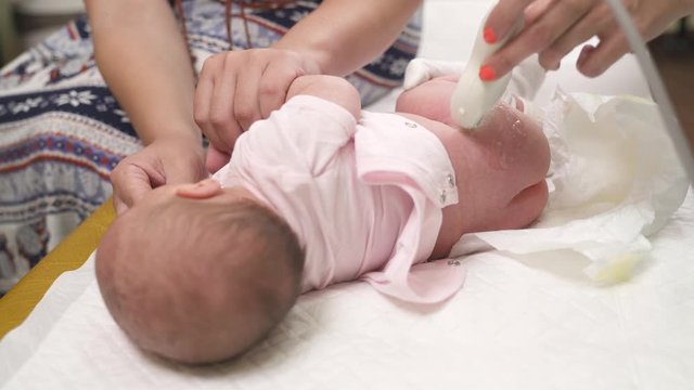 A Close-up Of A Neonatologist Performing Ultrasound Studying Of Infants Hip Joints. Hip Dysplasia. Pediatric Concept