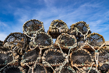 Pile of Mesh Rope Crab or Lobster Pots stacked up on the dock, blue sky background