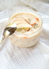 selective focus, still life, Breakfast. berry light peach yogurt with cereals in a glass jar with peach slices on a white tablecloth