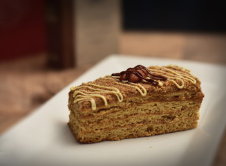 Sliced tasty chocolate & Caramel cake on wooden table background