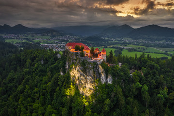 Bled, Slovenia - Aerial drone view of beautiful illuminated Bled Castle (Blejski Grad) with dark...